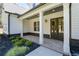 Front porch with brick flooring, white columns, and dark door at 1168 Harmony Dr, Canton, GA 30115