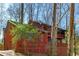 Red house nestled in woods with a deck at 3671 Prestwick Dr, Tucker, GA 30084