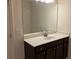 Bathroom boasts a vanity with dark brown cabinets and a large mirror at 7594 Shady Maple Way, Lithonia, GA 30038