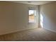 Well-lit bedroom with neutral walls and carpet, backyard view at 7594 Shady Maple Way, Lithonia, GA 30038