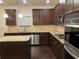 Modern kitchen with dark cabinetry, granite counters, and stainless steel appliances at 7594 Shady Maple Way, Lithonia, GA 30038