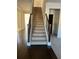 Elegant staircase with dark wood railing and neutral carpet at 7594 Shady Maple Way, Lithonia, GA 30038