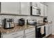 Modern kitchen with granite countertops, gray cabinets, and stainless steel appliances at 1752 Alford Dr, Jonesboro, GA 30236