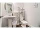 Clean and modern bathroom with pedestal sink and dark wood flooring at 4902 Glencree Sw Ct, Powder Springs, GA 30127