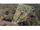 An aerial view shows the property boundaries and the house surrounded by mature trees at 675 Mayes Rd, Powder Springs, GA 30127