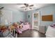 Bright bedroom featuring light blue walls, a ceiling fan, and a bed with stuffed animals at 675 Mayes Rd, Powder Springs, GA 30127