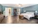 Open bedroom showcasing the ensuite bathroom, light-colored walls, and beautiful wood floors at 675 Mayes Rd, Powder Springs, GA 30127