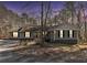 Well-maintained home featuring gray siding, dark shutters, and large windows under a twilight sky at 675 Mayes Rd, Powder Springs, GA 30127