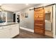 Charming kitchen area featuring modern cabinets, a rustic barn door and laundry hookups at 675 Mayes Rd, Powder Springs, GA 30127