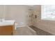 Walk-in shower with tile surround and built-in seat at 1308 Crumbley Rd, Mcdonough, GA 30252