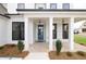 Covered front porch with brick flooring, white columns, and a blue door at 488 Broom Dr, Cumming, GA 30040