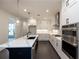 Modern kitchen with white cabinets, quartz countertops, and a large island at 488 Broom Dr, Cumming, GA 30040