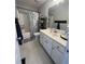 Bright bathroom featuring a vanity with white cabinets, a large mirror, and a shower-tub combo with a stylish curtain at 213 Moore Valley Way, Canton, GA 30115