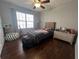 Cozy bedroom features a bed, dresser, hardwood floors, and natural light streaming in through the window at 213 Moore Valley Way, Canton, GA 30115