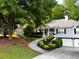 Charming home featuring a welcoming front yard, lush landscaping, and attached two-car garage at 213 Moore Valley Way, Canton, GA 30115