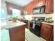 Well-lit kitchen featuring dark wood cabinets, granite countertops, and stainless steel appliances at 213 Moore Valley Way, Canton, GA 30115