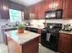 Well-equipped kitchen with dark wood cabinetry, granite countertops, and modern appliances at 213 Moore Valley Way, Canton, GA 30115