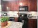 Beautiful kitchen featuring dark wood cabinetry, granite countertops, and stainless appliances at 213 Moore Valley Way, Canton, GA 30115
