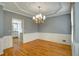 Elegant dining room with hardwood floors, chandelier, decorative wall trim, and a view into the kitchen at 205 Glenbrook Ln, Canton, GA 30115