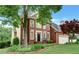 Beautifully landscaped front yard highlights this classic brick home with mature trees and attached two-car garage at 205 Glenbrook Ln, Canton, GA 30115