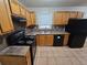 Updated kitchen featuring wood cabinets and black appliances at 3445 Mell Pl, Clarkston, GA 30021