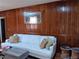 Living room features hardwood floors, a large white sofa, and wood wall paneling at 2479 Kingsland Dr, Dunwoody, GA 30360