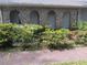 Close-up of a home's brick facade with arched entryways and lush green shrubbery at 2479 Kingsland Dr, Dunwoody, GA 30360
