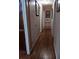 Hallway with hardwood floors, white walls, and decorative wall art leads to a bright living space at 2479 Kingsland Dr, Dunwoody, GA 30360