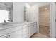 Bathroom featuring double sink vanity with white cabinets and mirror, next to a walk-in closet at 3256 Durston Ct, Dacula, GA 30019