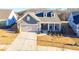 Aerial view of a lovely home featuring a two-car garage and charming dormers, nestled within a landscaped community at 4941 Adler Ct, Hoschton, GA 30548