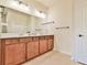 Bathroom with double sink vanity with wood cabinets, a large mirror, and tile flooring at 4941 Adler Ct, Hoschton, GA 30548