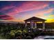 Outdoor hot tub, lush landscaping, wrought iron fence, and a covered pavilion during sunset at 4941 Adler Ct, Hoschton, GA 30548