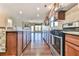 Open kitchen with stainless steel appliances, wooden cabinets and center island overlooking the living room at 4941 Adler Ct, Hoschton, GA 30548