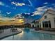 Resort style swimming pool at sunset with community center and lounge chairs at 4941 Adler Ct, Hoschton, GA 30548