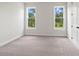 Bright bedroom with neutral carpeting and two windows at 507 Pearl St, Cumming, GA 30040