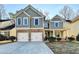 Two-story house with gray siding, stone accents, and a two-car garage at 2084 Nelms Pointe Lndg, Lawrenceville, GA 30043