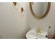 Small bathroom with pedestal sink and mirror at 2335 Corbett Ct, Powder Springs, GA 30127