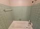 Clean bathroom with light green tiled walls and bathtub at 385 Shannon Way, Lawrenceville, GA 30044