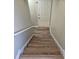 Modern staircase with light wood laminate flooring and white railings at 10577 Marigold Ct, Hampton, GA 30228