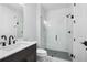 Modern bathroom with glass enclosed shower, marble floors, and dark vanity at 515 Pearl St, Cumming, GA 30040