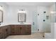 Bathroom with double vanities, wooden cabinetry, and a glass-enclosed shower at 515 Pearl St, Cumming, GA 30040
