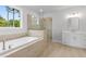 Spa-like bathroom with a soaking tub, walk-in shower, and modern vanity at 515 Pearl St, Cumming, GA 30040