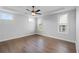 Bright bedroom featuring hardwood floors, tray ceiling, and a ceiling fan at 515 Pearl St, Cumming, GA 30040