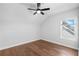 Bright bedroom featuring hardwood floors, a ceiling fan, and a window at 515 Pearl St, Cumming, GA 30040