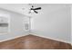 Bright bedroom featuring hardwood floors, a ceiling fan, and natural light at 515 Pearl St, Cumming, GA 30040