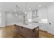 Island kitchen with white cabinets, quartz countertops, and hardwood floors at 515 Pearl St, Cumming, GA 30040