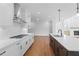 Contemporary kitchen with white countertops, white cabinets, stainless steel range hood, and hardwood floors at 515 Pearl St, Cumming, GA 30040