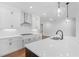 Elegant kitchen with white cabinets, stainless steel range hood, hardwood floors, a kitchen island, and quartz countertops at 515 Pearl St, Cumming, GA 30040