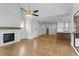 Open concept living space with hardwood floors, a fireplace, and kitchen views at 515 Pearl St, Cumming, GA 30040