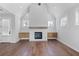 Spacious living room featuring a fireplace, hardwood floors, built-in cabinets, a door, and multiple windows at 515 Pearl St, Cumming, GA 30040